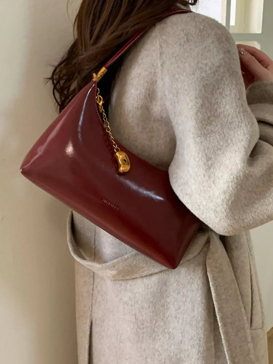 Evie's Dreamland burgundy PU leather shoulder bag with a gold chain charm, styled with a beige coat