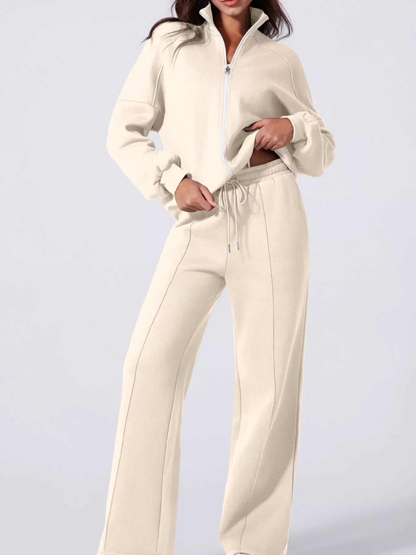 Woman wearing beige zip-up fleece jacket and matching wide-leg sweatpants casual loungewear outfit