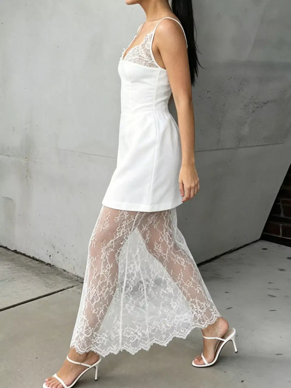 Evie's Dreamland white lace corset mini dress with a sheer lace overlay skirt and white heels.