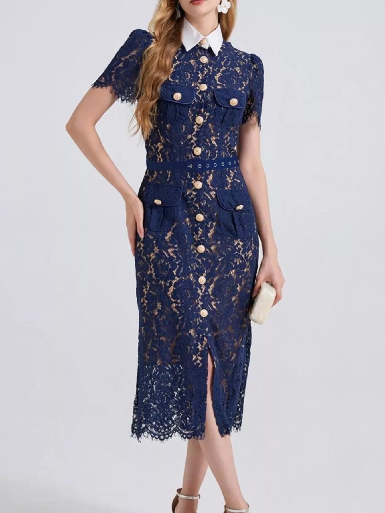 Woman wearing a navy blue lace midi dress with white collar and gold buttons