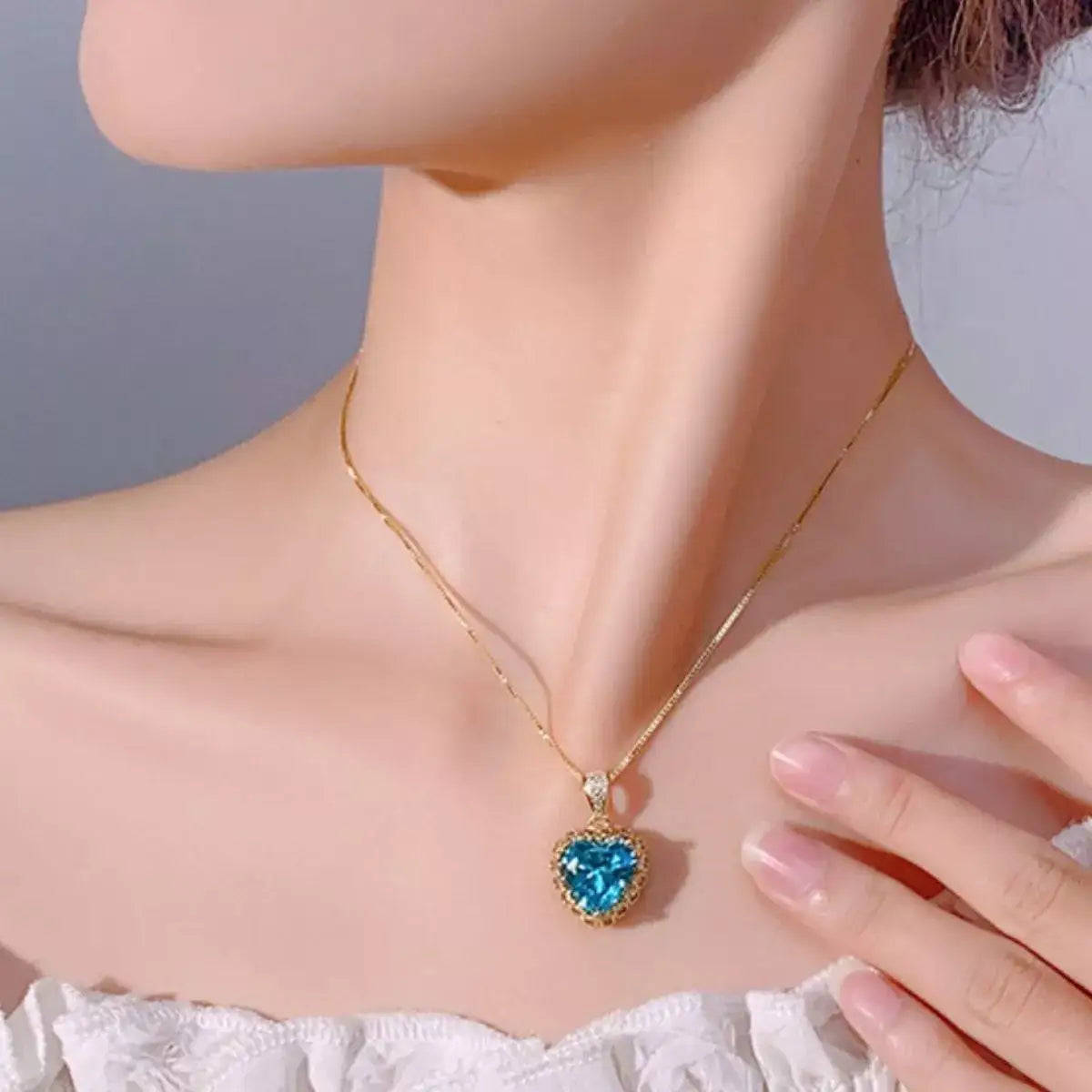 Woman wearing an Evie's Dreamland 18K gold-plated necklace with a heart-shaped aquamarine pendant.