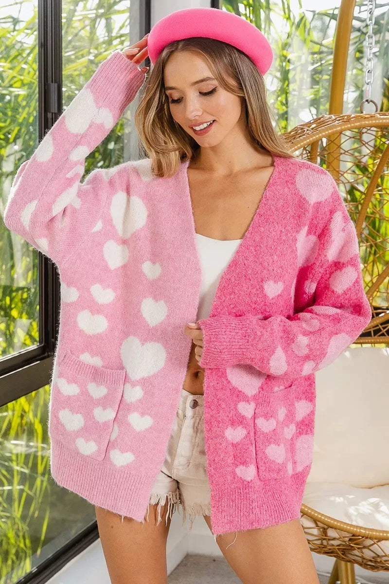 Young woman wearing fluffy pink and white heart-patterned cardigan and pink beret indoors near window