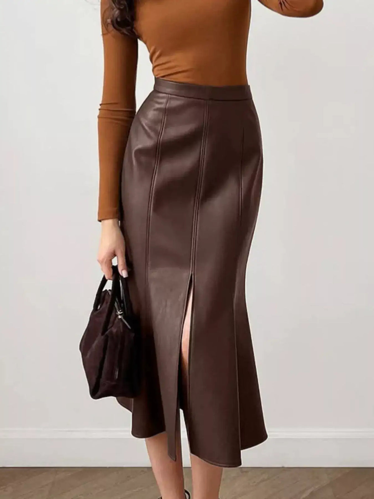 Woman wearing a brown faux leather slit mermaid midi skirt by Evie's Dreamland with a brown top.