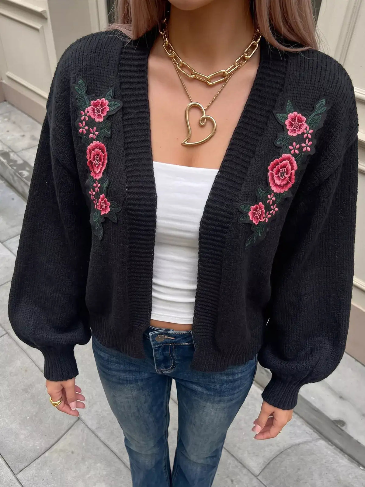 Evie's Dreamland black knit cardigan with floral embroidery, balloon sleeves, worn over a white top.
