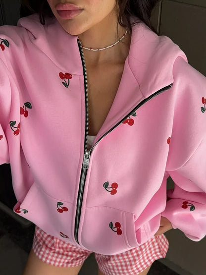 Close-up of woman wearing pink zip-up hoodie with cherry print and pink checkered shorts