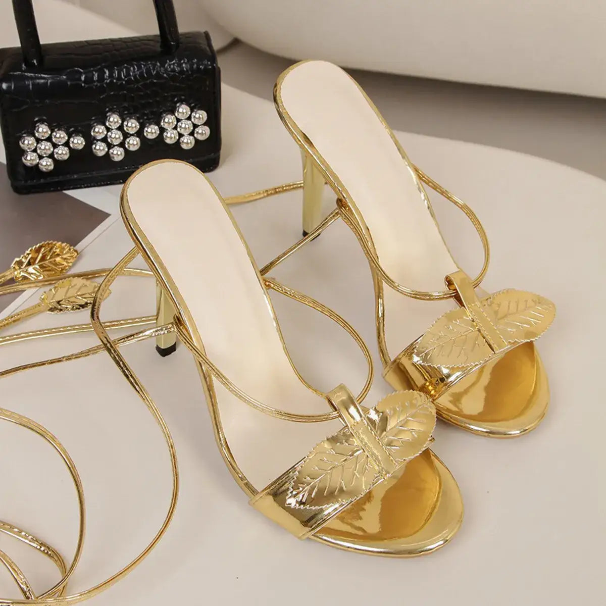 Gold lace-up high heel sandals by Evie's Dreamland featuring leaf-shaped metallic straps.