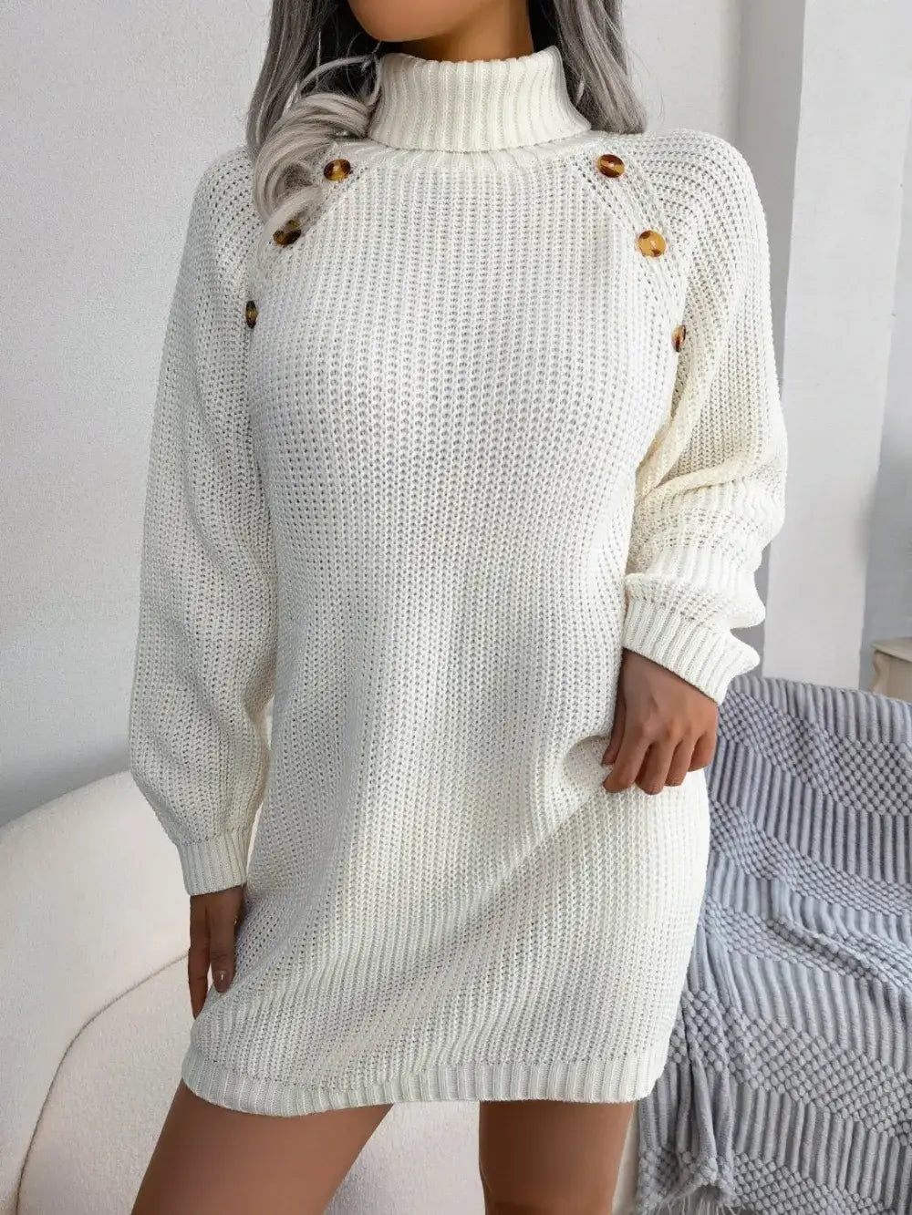 White knit turtleneck sweater dress by Evie's Dreamland with decorative shoulder buttons and long sleeves.