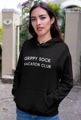 Model smiling while wearing the Grippy Sock Vacation Club Hoodie casually.